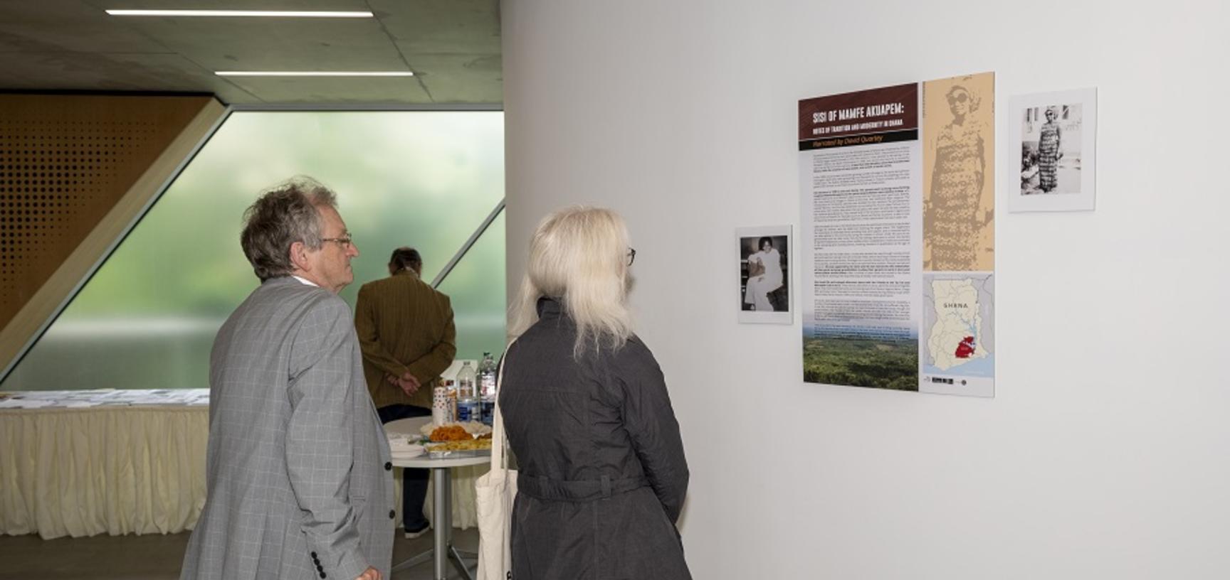 two people looking at posters on the wall