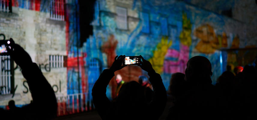torch  oxford castle at 950 years  son et lumiere oa - photo of the projection on the side of the castle, with the audience holding up their phones to take a photo of it!