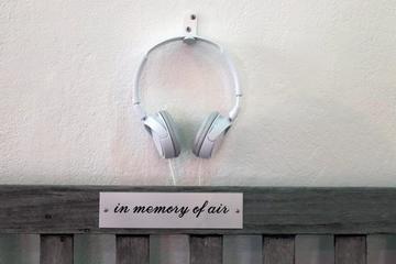 white headphones attached to wall above plaque which reads in memory of air