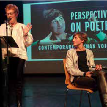 Karen Leeder (standing) and Almut Sandig (sitting) speaking at a conference regarding Mediating modern poetry