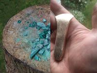 Image split in two; left image shows tree stump with shattered blue topaz, right image shows a hand holding a bronze artifact