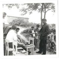 Monochrome image depicts Linguist Tony Hurren recording an interview with people in Kostrčan(i) in the 1960s.